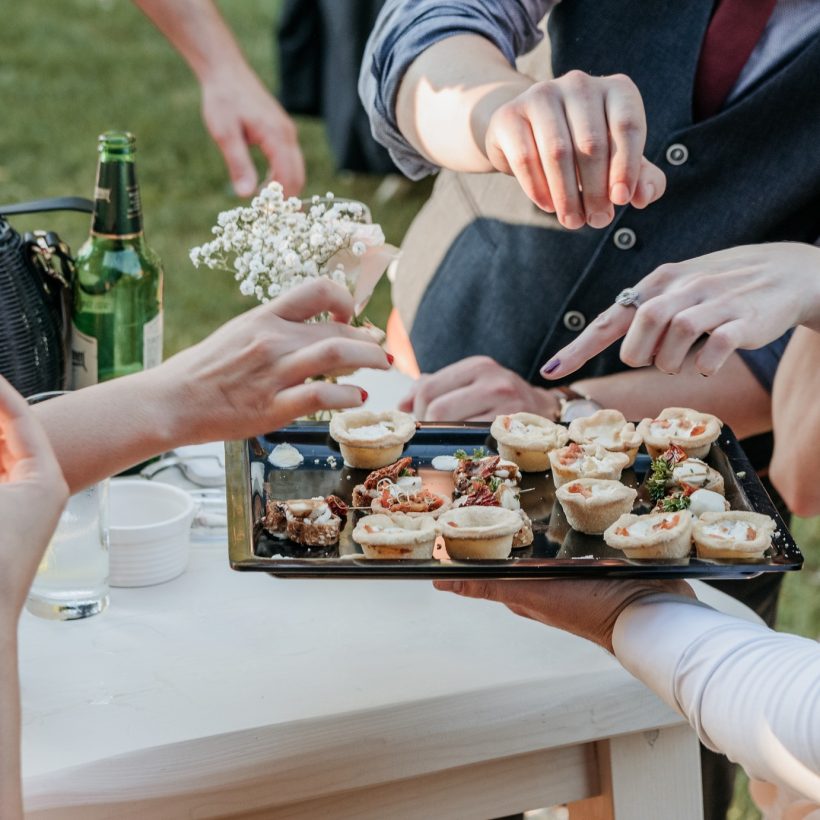 Group of friends eating finger food at a wedding reception Group of friends eating finger food at a wedding reception